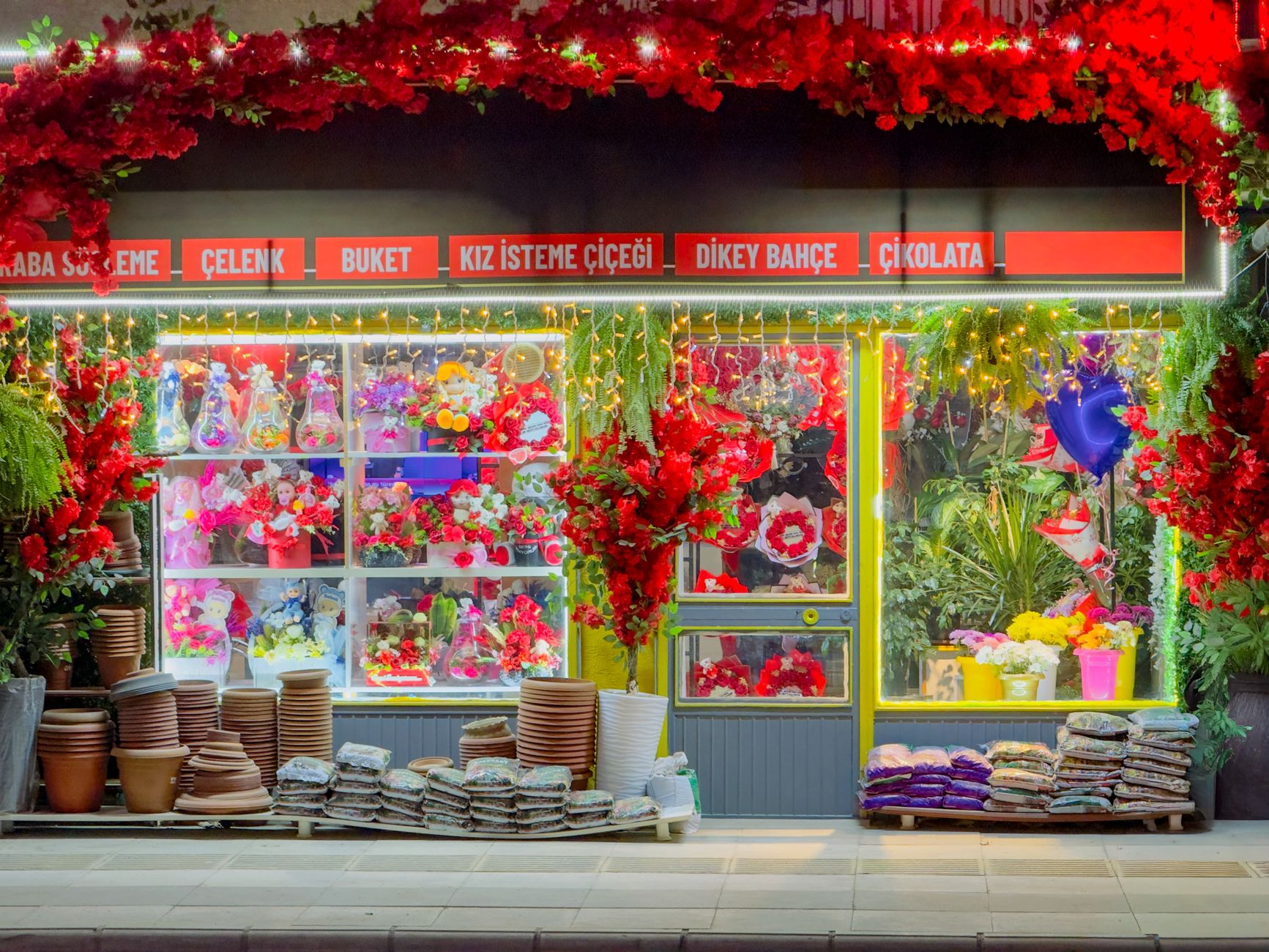 A vibrant floral shopfront in Elâzığ, Türkiye, illuminated at night with colorful flowers and decorative lighting. — Free Spi