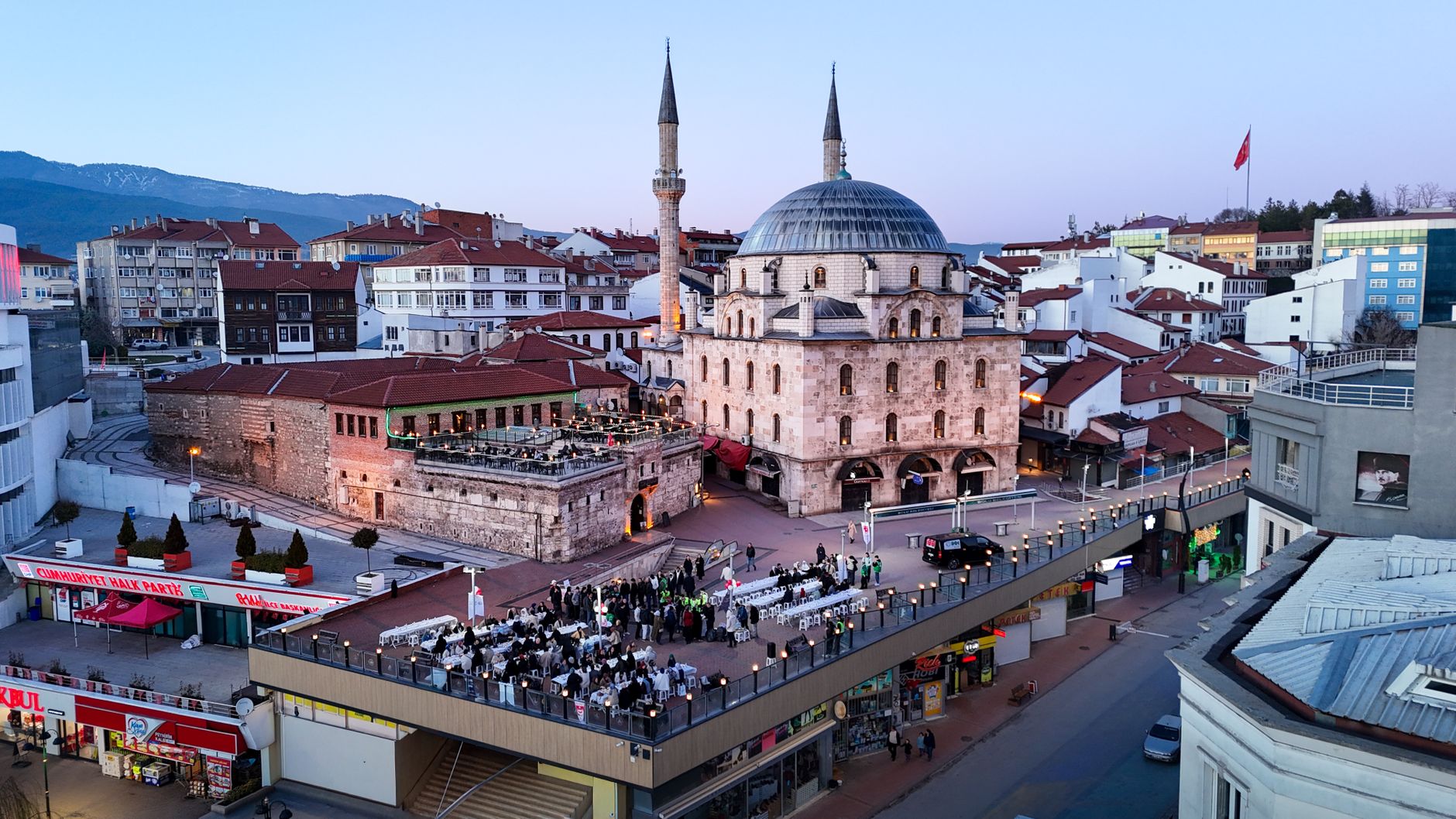 Aerial shot of Bolu city with a prominent mosque and bustling streets during twilight. — Leveraging Strategic Leadership: Nih