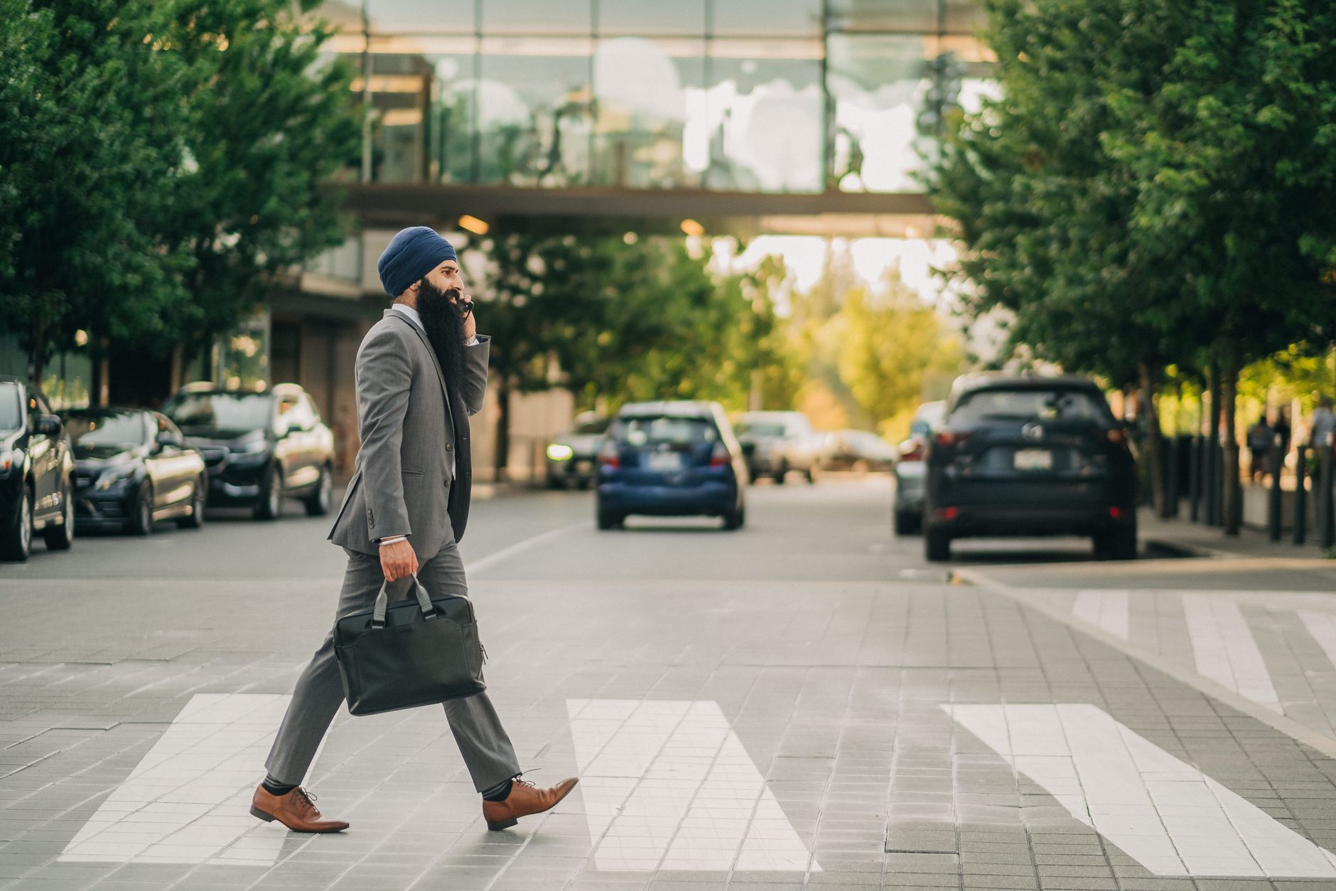 Sikh businessman with a turban crossing a city street on a zebra crossing, carrying a briefcase. — Steps to Setting Up an Exc