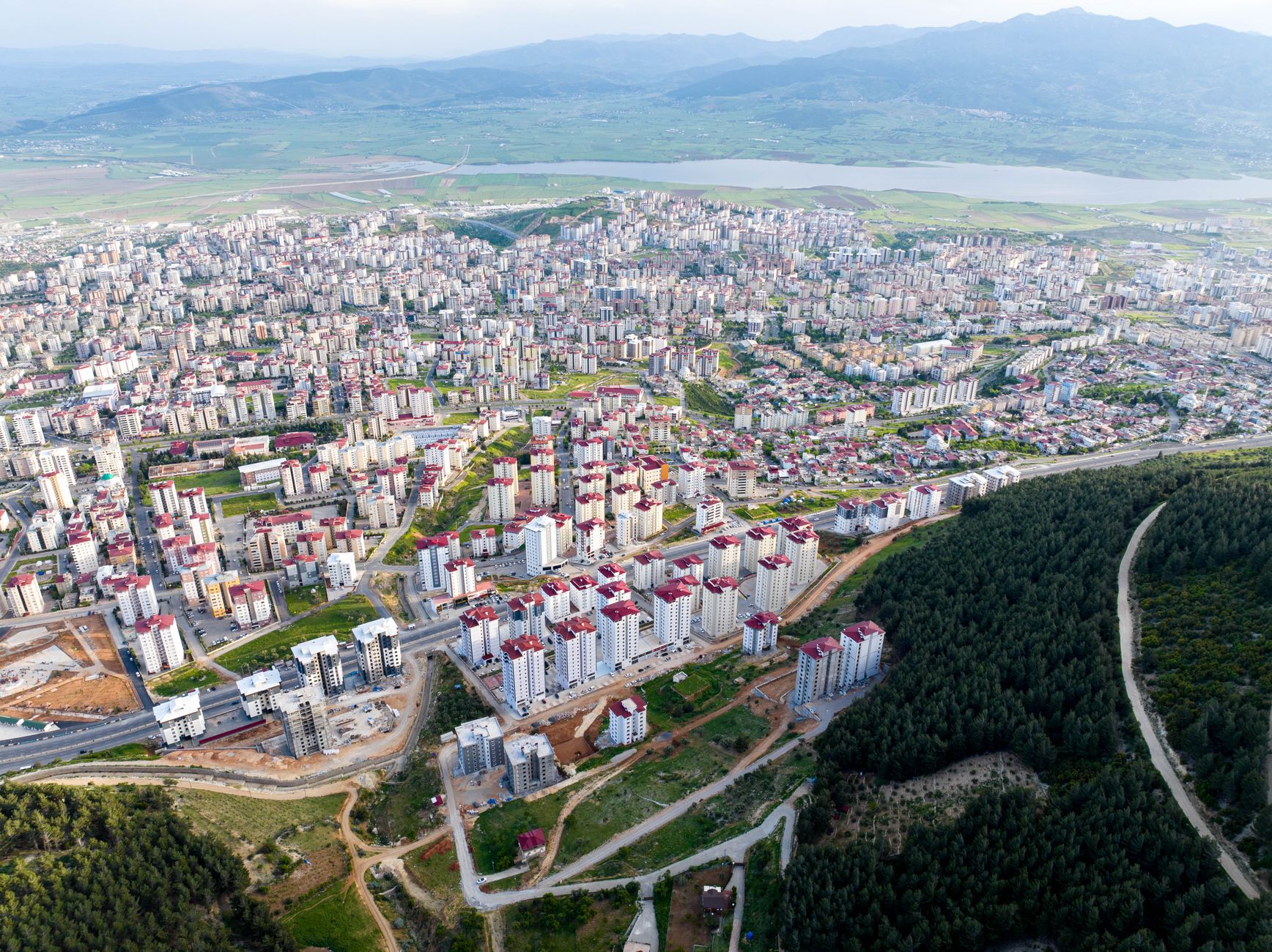 Aerial view showcasing the urban expansion and landscape of a vibrant city surrounded by nature. — The Revolutionary Future o